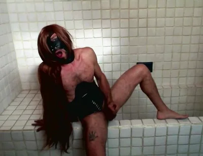Long Hair Sissy in Corset Uses Gagball in Bathroom