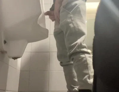 2 Boys in Sneakers Having Fun at Public Toilets' Urinal